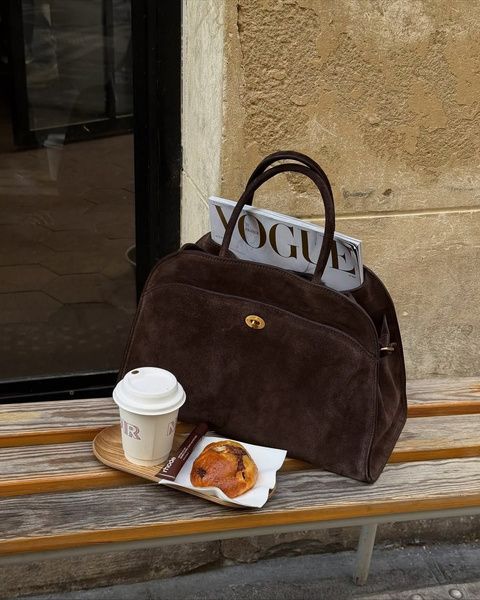 Leather handbag with a magazine and coffee