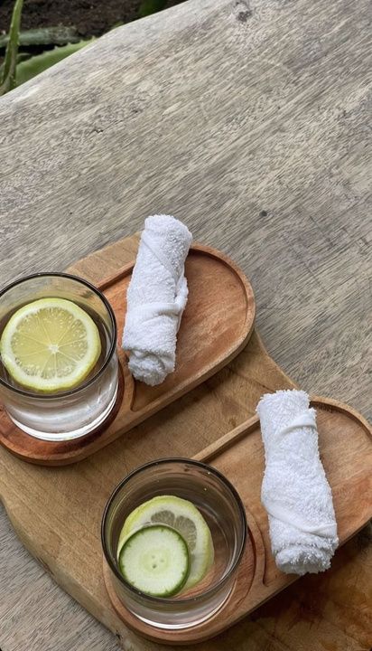 Welcome drinks and rolled towels on a wooden tray